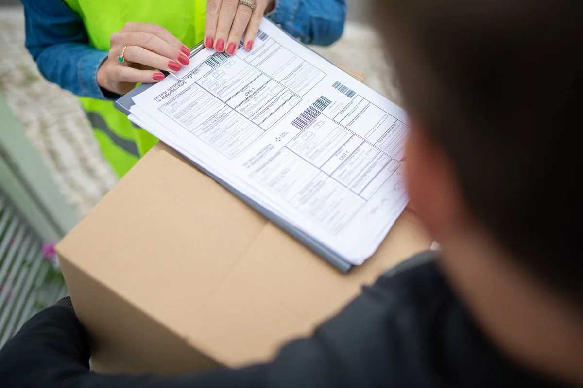 Courier handing a parcel to a customer for delivery confirmation